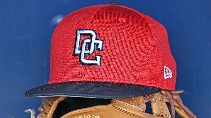 Red Washington Nationals hat on top of a light brown mitt Red Washington Nationals hat on top of a light brown mitt