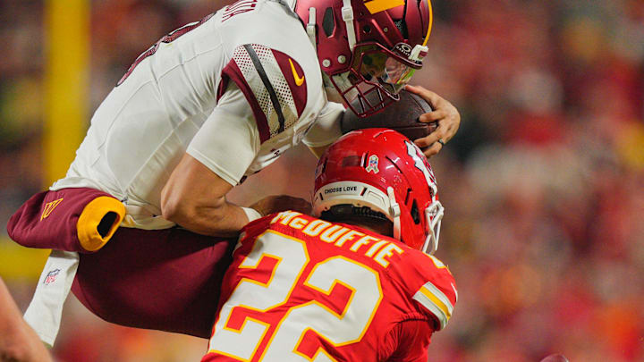 Oct 27, 2025; Kansas City, Missouri, USA; Kansas City Chiefs cornerback Trent McDuffie (22) tackles Washington Commanders quarterback Marcus Mariota (8) during the second quarter of the game at GEHA Field at Arrowhead Stadium. Mandatory Credit: Jay Biggerstaff-Imagn Images