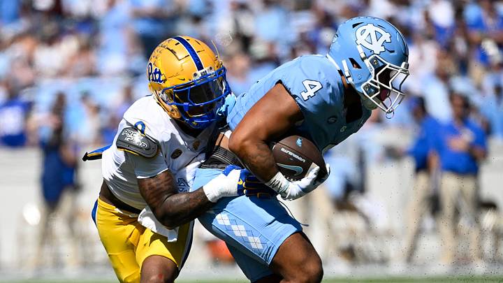 Oct 5, 2024; Chapel Hill, North Carolina, USA; North Carolina Tar Heels running back Caleb Hood (4) with the ball as Pittsburgh Panthers linebacker Kyle Louis (9) defends in the second quarter at Kenan Memorial Stadium. Mandatory Credit: Bob Donnan-Imagn Images Oct 5, 2024; Chapel Hill, North Carolina, USA; North Carolina Tar Heels running back Caleb Hood (4) with the ball as Pittsburgh Panthers linebacker Kyle Louis (9) defends in the second quarter at Kenan Memorial Stadium. Mandatory Credit: Bob Donnan-Imagn Images