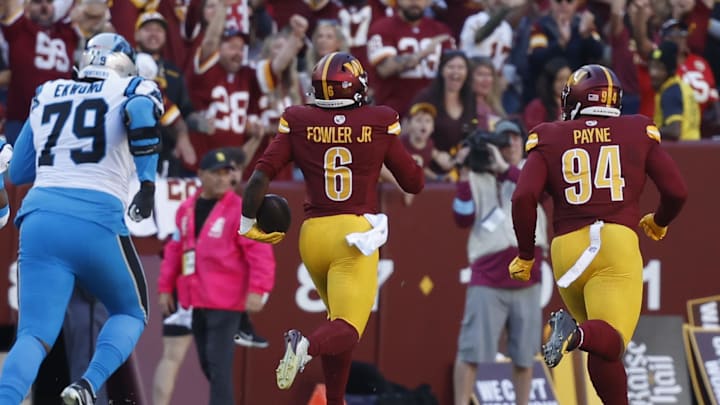 Oct 20, 2024; Landover, Maryland, USA; Washington Commanders linebacker Dante Fowler Jr. (6) returns an interception for a touchdown against the Carolina Panthers during the first quarter at Northwest Stadium. Mandatory Credit: Geoff Burke-Imagn Images
