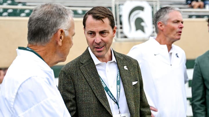 Michigan State's Athletic Director J Batt, center, talks with former football coach Mark Dantonio before the football game against Western Michigan on Friday, Aug. 29, 2025, in East Lansing.