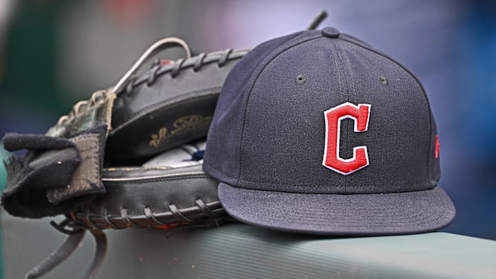 Jun 27, 2024; Kansas City, Missouri, USA; A general view a Cleveland Guardians hat and glove on the dugout railing  before a game against the Kansas City Royals at Kauffman Stadium. Mandatory Credit: Peter Aiken-Imagn Images