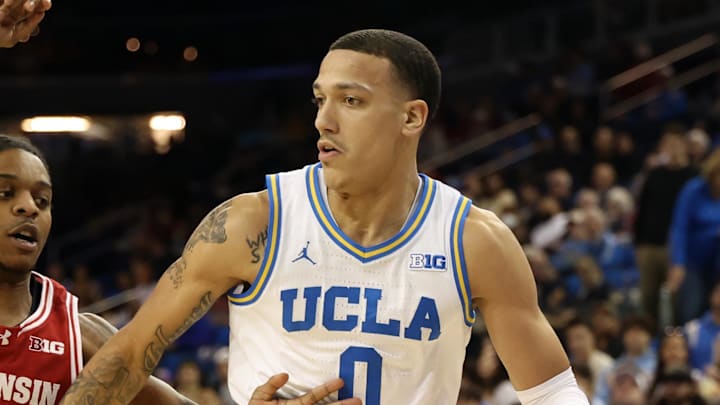 Jan 21, 2025; Los Angeles, California, USA;  UCLA Bruins guard Kobe Johnson (0) dribbles the ball against Wisconsin Badgers guard Kamari McGee (4) during the first half at Pauley Pavilion presented by Wescom. Mandatory Credit: Kiyoshi Mio-Imagn Images