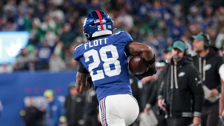 Oct 9, 2025; East Rutherford, New Jersey, USA; New York Giants cornerback Cor'Dale Flott (28) carries the ball after an interception against the Philadelphia Eagles during the fourth quarter of the game at MetLife Stadium. Mandatory Credit: Vincent Carchietta-Imagn Images