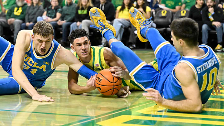 Dec 8, 2024; Eugene, Oregon, USA; Oregon Ducks guard Jackson Shelstad (3) battles for the ball against  UCLA Bruins forward Tyler Bilodeau (34) and guard Lazar Stefanovic (10) in the first half at Matthew Knight Arena. Mandatory Credit: Craig Strobeck-Imagn Images