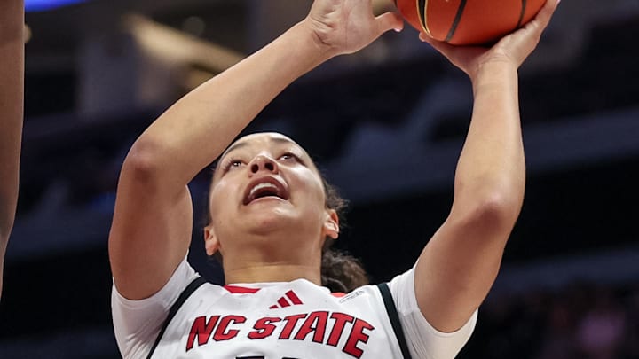 Nov 9, 2025; Charlotte, North Carolina, USA; NC State Wolfpack forward Khamil Pierre (12) shoots for the basket over Southern California Trojans forward Vivian Iwuchukwu (0) during the first quarter of the Ally Tipoff game at Spectrum Center. Mandatory Credit: Cory Knowlton-Imagn Images