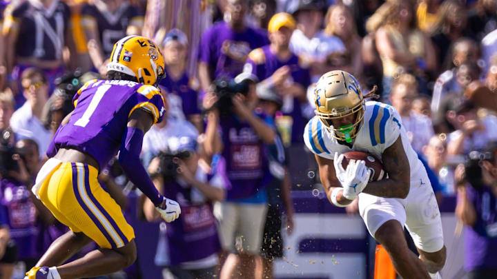 Sep 21, 2024; Baton Rouge, Louisiana, USA; UCLA Bruins wide receiver Rico Flores Jr. (1) runs with the ball against LSU Tigers cornerback Ashton Stamps (1) during the first half at Tiger Stadium. Mandatory Credit: Stephen Lew-Imagn Images Sep 21, 2024; Baton Rouge, Louisiana, USA; UCLA Bruins wide receiver Rico Flores Jr. (1) runs with the ball against LSU Tigers cornerback Ashton Stamps (1) during the first half at Tiger Stadium. Mandatory Credit: Stephen Lew-Imagn Images