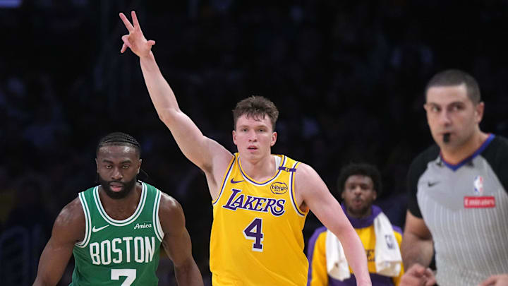 Jan 23, 2025; Los Angeles, California, USA; Los Angeles Lakers guard Dalton Knecht (4) celebrates after a three-point basket as Boston Celtics guard Jaylen Brown (7) watches in the first half at Crypto.com Arena. Mandatory Credit: Kirby Lee-Imagn Images