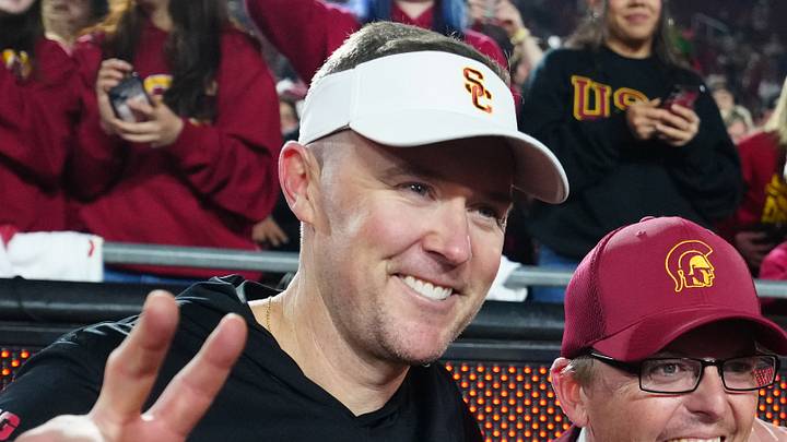 Nov 29, 2025; Los Angeles, California, USA; Southern California Trojans head coach Lincoln Riley (left) poses with Spirit of Troy marching band director James Vogel (center) and mascot Tommy Trojan after the game against the UCLA Bruins at United Airlines Field at Los Angeles Memorial Coliseum. Mandatory Credit: Kirby Lee-Imagn Images Nov 29, 2025; Los Angeles, California, USA; Southern California Trojans head coach Lincoln Riley (left) poses with Spirit of Troy marching band director James Vogel (center) and mascot Tommy Trojan after the game against the UCLA Bruins at United Airlines Field at Los Angeles Memorial Coliseum. Mandatory Credit: Kirby Lee-Imagn Images