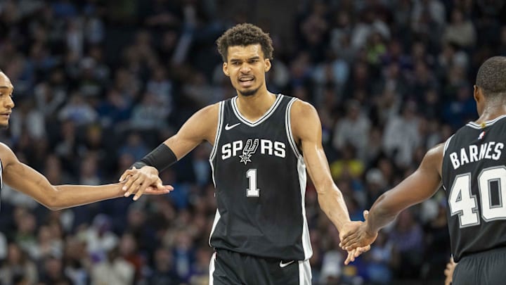Dec 29, 2024; Minneapolis, Minnesota, USA; San Antonio Spurs center Victor Wembanyama (1) celebrates with San Antonio Spurs guard Devin Vassell (24) and San Antonio Spurs forward Harrison Barnes (40) after making a shot against the Minnesota Timberwolves in the second half at Target Center. Mandatory Credit: Jesse Johnson-Imagn Images