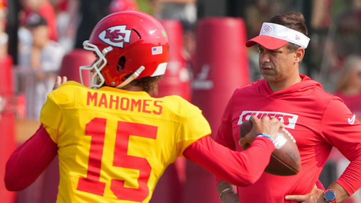 Jul 26, 2024; Kansas City, MO, USA; Kansas City Chiefs quarterback Patrick Mahomes (15) throws a pass as general manager Brett Veach watches in the background during training camp at Missouri Western State University. Mandatory Credit: Denny Medley-Imagn Images