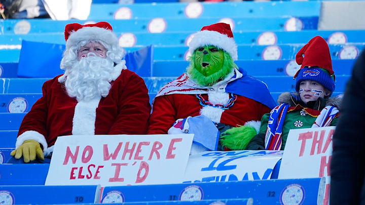 A couple of fans, dressed up in Christmas costumes, watch the players warm at Highmark Stadium in Orchard Park on Dec. 22, 2024.