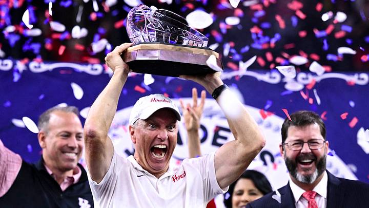 Dec 27, 2025; Houston, TX, USA; Houston Cougars head coach Willie Fritz hoists the champions trophy after the win over Louisiana State Tigers at NRG Stadium. Mandatory Credit: Maria Lysaker-Imagn Images