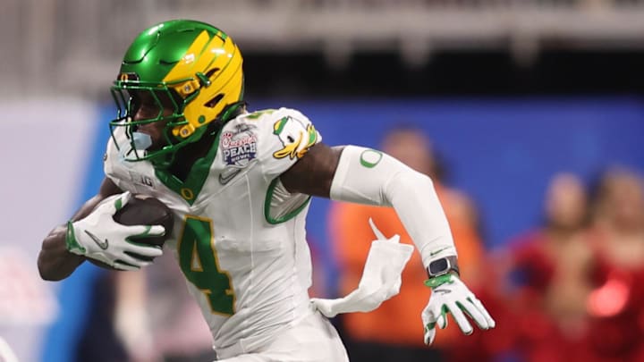 Jan 9, 2026; Atlanta, GA, USA; Oregon Ducks wide receiver Malik Benson (4) runs the ball against Indiana Hoosiers defensive back Louis Moore (7) during the first quarter of the 2025 Peach Bowl and semifinal game of the College Football Playoff at Mercedes-Benz Stadium. Mandatory Credit: Brett Davis-Imagn Images