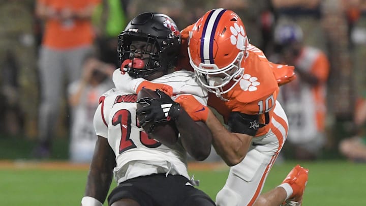 Nov 2, 2024; Clemson, South Carolina, USA; Clemson Tigers cornerback Jeadyn Lukus (10) tackles Louisville Cardinals running back Isaac Brown (25) during the first quarter at Memorial Stadium.