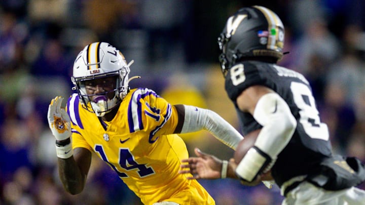 Nov 23, 2024; Baton Rouge, Louisiana, USA; LSU Tigers cornerback Zy Alexander (14) tackles Vanderbilt Commodores quarterback Nate Johnson (8) during the second half at Tiger Stadium.