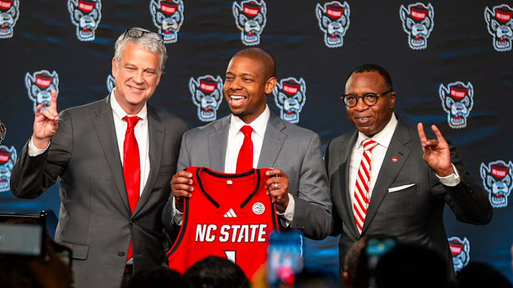 NC State AD Boo Corrigan, men's basketball coach Justin Gainey and Chancellor Kevin Howell pose at Gainey's introductory press conference at the Lenovo Center on Wednesday, April 1, 2026. 