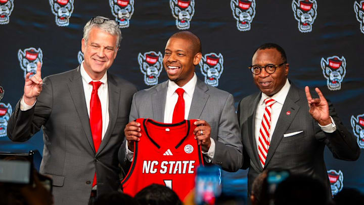 NC State AD Boo Corrigan, men's basketball coach Justin Gainey and Chancellor Kevin Howell pose at Gainey's introductory press conference at the Lenovo Center on Wednesday, April 1, 2026. NC State AD Boo Corrigan, men's basketball coach Justin Gainey and Chancellor Kevin Howell pose at Gainey's introductory press conference at the Lenovo Center on Wednesday, April 1, 2026.