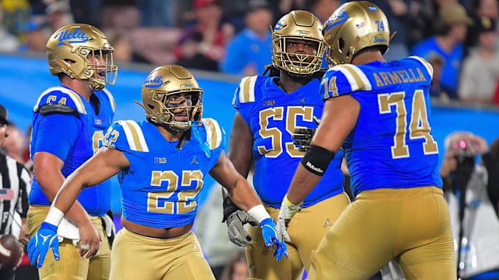 Nov 8, 2025; Pasadena, California, USA; UCLA Bruins running back Anthony Frias II (22) celebrates his touchdown scored against the Nebraska Cornhuskers with offensive lineman Julian Armella (74) during the second half at the Rose Bowl. Mandatory Credit: Gary A. Vasquez-Imagn Images