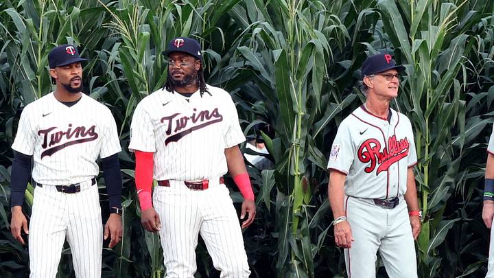 Members of the Minnesota Twins and Philadelphia Phillies walk out of the corn Members of the Minnesota Twins and Philadelphia Phillies walk out of the corn