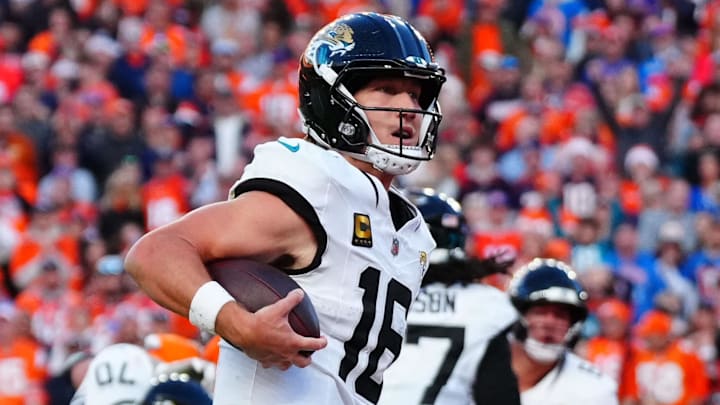Dec 21, 2025; Denver, Colorado, USA; Jacksonville Jaguars quarterback Trevor Lawrence (16) rushes for a touchdown against the Denver Broncos during the second half at Empower Field at Mile High. Mandatory Credit: Ron Chenoy-Imagn Images
