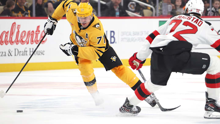 Feb 26, 2026; Pittsburgh, Pennsylvania, USA;  Pittsburgh Penguins center Evgeni Malkin (71) moves the puck against New Jersey Devils center Nick Bjugstad (72) during the third period at PPG Paints Arena. Mandatory Credit: Charles LeClaire-Imagn Images