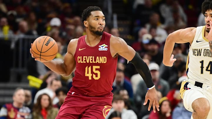 Dec 23, 2025; Cleveland, Ohio, USA; Cleveland Cavaliers guard Donovan Mitchell (45) brings the ball up court against New Orleans Pelicans guard Micah Peavy (14) during the second half at Rocket Arena. Mandatory Credit: Ken Blaze-Imagn Images