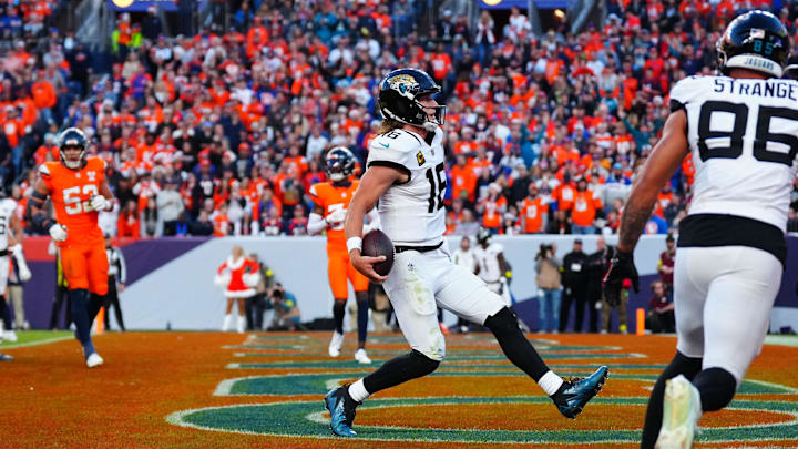 Dec 21, 2025; Denver, Colorado, USA; Jacksonville Jaguars quarterback Trevor Lawrence (16) rushes for a touchdown against the Denver Broncos during the second half at Empower Field at Mile High. Mandatory Credit: Ron Chenoy-Imagn Images