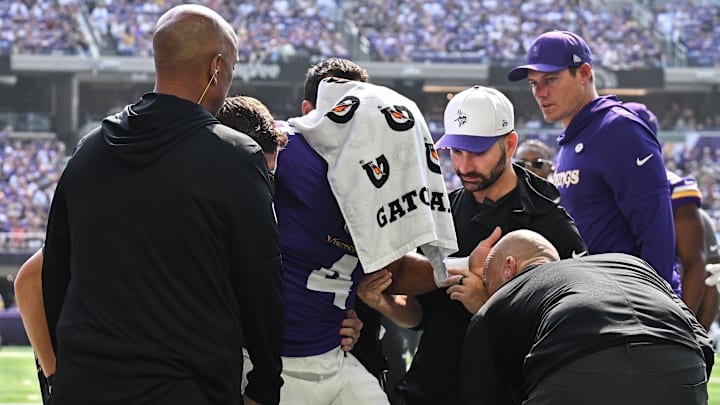 Aug 9, 2025; Minneapolis, Minnesota, USA; Minnesota Vikings wide receiver Rondale Moore (4) is attended to by head coach Kevin O'Connell and trainers after suffering a lower leg injury during the second quarter against the Houston Texans at U.S. Bank Stadium. Mandatory Credit: Jeffrey Becker-Imagn Images