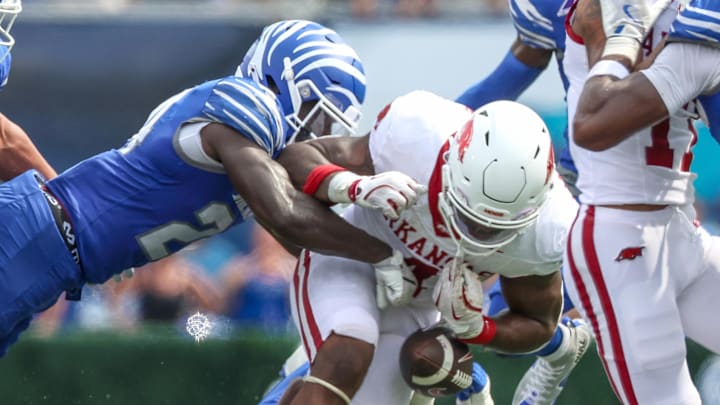 Memphis Tigers defensive back Kamari Wilson forces a fumble against Arkansas Razorbacks running back Mike Washington Jr. (4) during the second half at Simmons Bank Liberty Stadium.