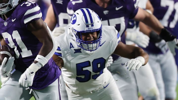 Sep 21, 2024; Provo, Utah, USA; Kansas State Wildcats running back DJ Giddens (31) runs from Brigham Young Cougars linebacker Aisea Moa (58) and linebacker Isaiah Glasker (16) during the first quarter at LaVell Edwards Stadium. Mandatory Credit: Rob Gray-Imagn Images