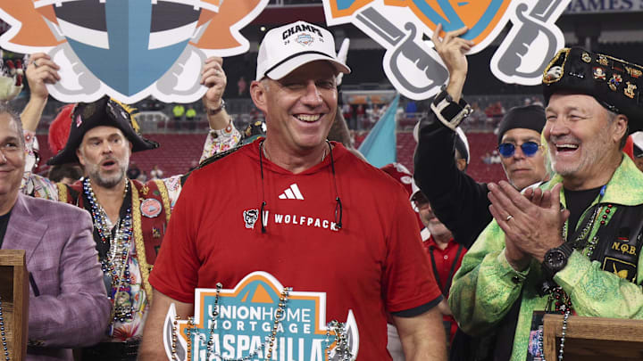 Dec 19, 2025; Tampa, FL, USA; NC State Wolfpack head coach Dave Doeren receives the trophy after beating Memphis Tigers in the Gasparilla Bowl at Raymond James Stadium. Mandatory Credit: Nathan Ray Seebeck-Imagn Images