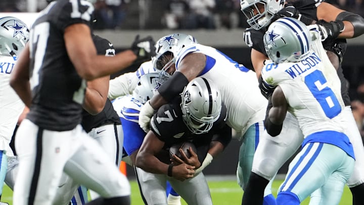Las Vegas Raiders quarterback Geno Smith is sacked by Dallas Cowboys defensive tackles Kenny Clark and Quinnen Williams
