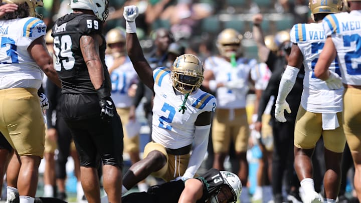 Aug 31, 2024; Honolulu, Hawaii, USA;  UCLA Bruins linebacker Oluwafemi Oladejo (2) reacts after tackling Hawaii Rainbow Warriors quarterback Brayden Schager (13) during the 2nd quarter of an NCAA college football game at the Clarence T.C. Ching Athletics Complex. Mandatory Credit: Marco Garcia-Imagn Images