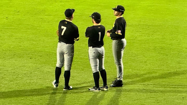 Ben Higdon, Joey Urban, and Davis Gillespie talk things over in the Southern Miss outfield.