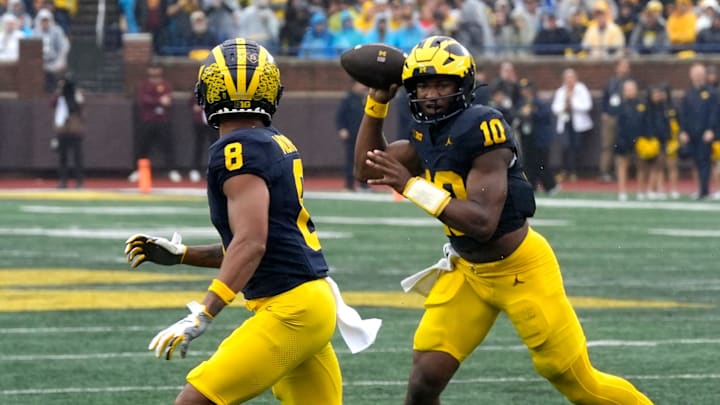Michigan quarterback Alex Orji runs as he throws to wide receiver Tyler Morris during first half action between the Michigan and Minnesota at Michigan Stadium in Ann Arbor on Saturday, Sept. 28, 2024.