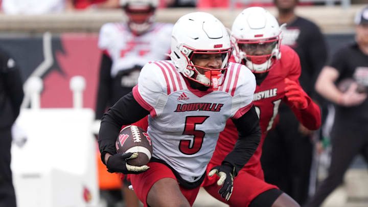 White Louisville’s Caullin Lacy (5) catches the ball and ran from some yardage against Red Louisville in the Spring Game Friday night at L & N Stadium.