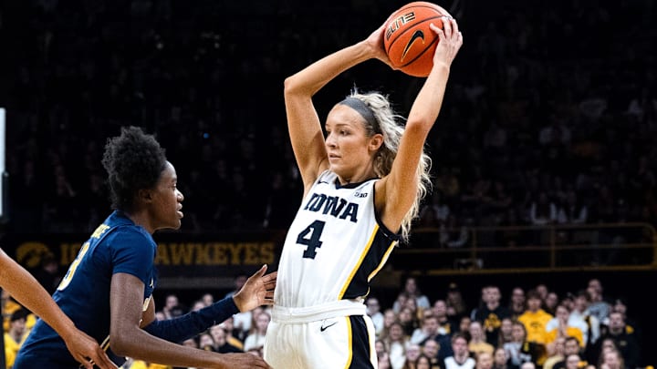 Iowa guard Kylie Feuerbach (4) looks to pass the basketball as Iowa forward Hannah Stuelke (45) feigns a screen Feb. 22, 2026 at Carver-Hawkeye Arena in Iowa City, Iowa.