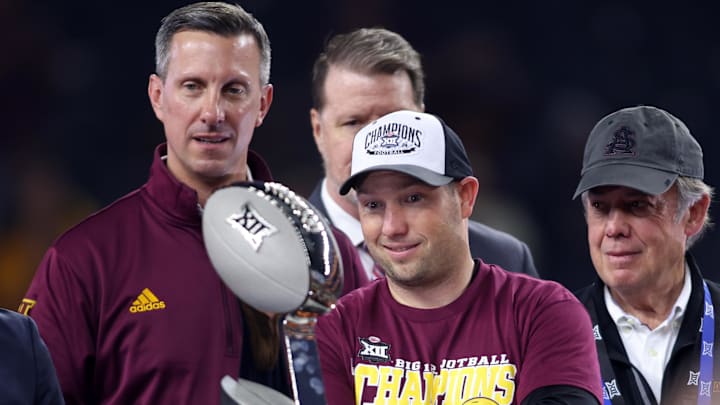 Dec 7, 2024; Arlington, TX, USA; Arizona State Sun Devils head coach Kenny Dillingham looks at the trophy after winning the Big 12 Championship game against the Iowa State Cyclones at AT&T Stadium. Mandatory Credit: Tim Heitman-Imagn Images