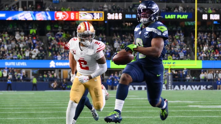 Seattle Seahawks RB Kenneth Walker III carries the ball for a touchdown as San Francisco 49ers CB Deommodore Lenoir trails.