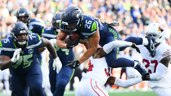 Nov 9, 2025; Seattle, Washington, USA; Seattle Seahawks running back Zach Charbonnet (26) leaps over Arizona Cardinals safety Jalen Thompson (34) for a touchdown during the second quarter at Lumen Field. Mandatory Credit: Steven Bisig-Imagn Images
