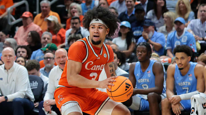 Feb 10, 2026; Coral Gables, Florida, USA; Miami Hurricanes guard Tre Donaldson (3) protects the basketball from North Carolina Tar Heels forward Jonathan Powell (11) during the first half at Watsco Center. Mandatory Credit: Sam Navarro-Imagn Images