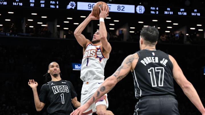 Jan 19, 2026; Brooklyn, New York, USA; Phoenix Suns guard Devin Booker (1) shoots the ball against Brooklyn Nets forward Ziaire Williams (1) during the second half at Barclays Center. Mandatory Credit: John Jones-Imagn Images