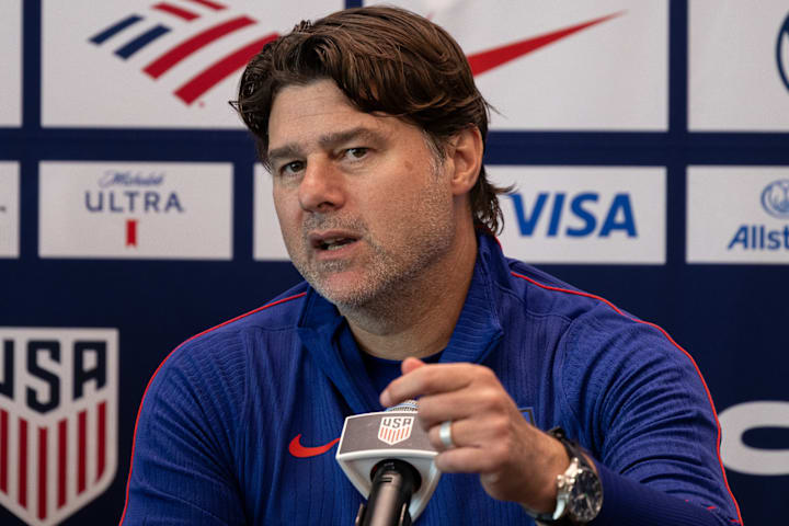 เมาริซิโอ โปเชตติโน ยืนอยู่หน้าไมโครโฟน