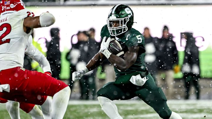 Michigan State's Nate Carter, right, runs the ball as Rutgers' Iyreem Powell closes in during the fourth quarter on Saturday, Nov. 30, 2024, at Spartan Stadium in East Lansing.