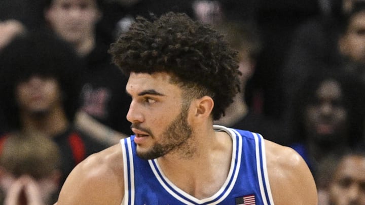 Jan 6, 2026; Louisville, Kentucky, USA;  Duke Blue Devils forward Cameron Boozer (12) charges into Louisville Cardinals forward Khani Rooths (9) during the second half at KFC Yum! Center. Mandatory Credit: Jamie Rhodes-Imagn Images