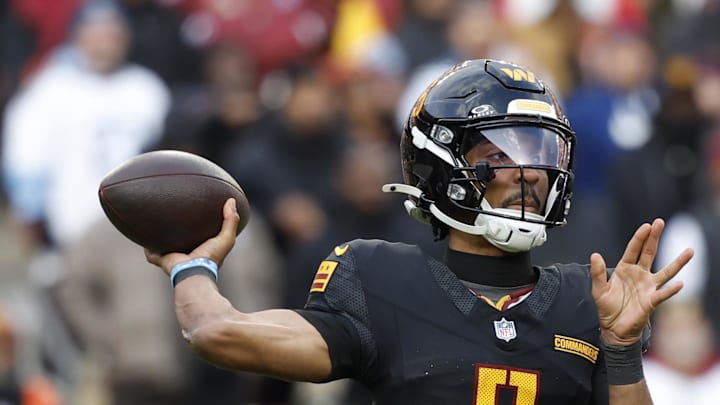 Dec 1, 2024; Landover, Maryland, USA; Washington Commanders quarterback Jayden Daniels (5) passes the ball as Tennessee Titans linebacker Arden Key (49) chases during the third quarter at Northwest Stadium. Mandatory Credit: Geoff Burke-Imagn Images