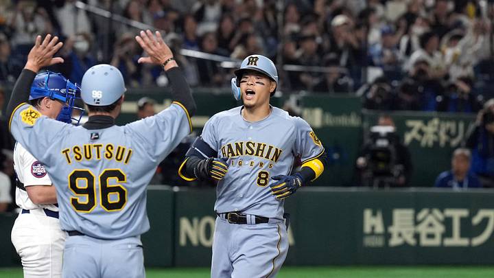 Mar 16, 2025; Bunkyo, Tokyo, Japan; Hanshin Tigers third baseman Teruaki Sato (8) celebrates with teammates after hitting a home run against the Los Angeles Dodgers during the fourth inning at Tokyo Dome. Mandatory Credit: Darren Yamashita-Imagn Images