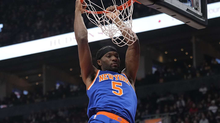 Dec 9, 2024; Toronto, Ontario, CAN; New York  Knicks forward Precious Achiuwa (5) hangs on the rim after making a basket against the Toronto Raptors during the first half at Scotiabank Arena. Mandatory Credit: John E. Sokolowski-Imagn Images