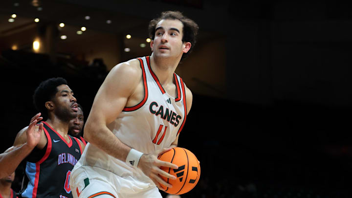 Nov 23, 2025; Coral Gables, Florida, USA; Miami Hurricanes center Salih Altuntas (11) drives to the basket against Delaware State Hornets guard Rahmir Moore (0) during the second half at Watsco Center. Mandatory Credit: Sam Navarro-Imagn Images